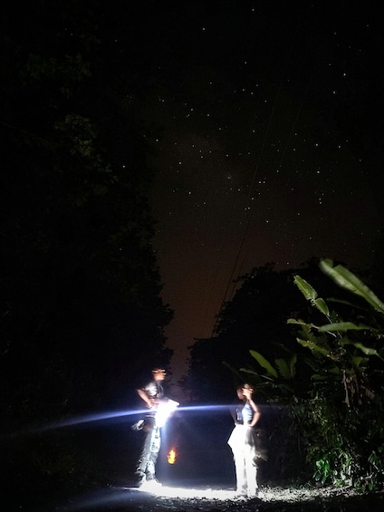 Two people standing under a streetlight at night with stars visible in the sky. 2
