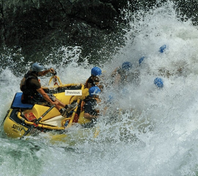 A group of people in a yellow raft navigating through a turbulent river. 2