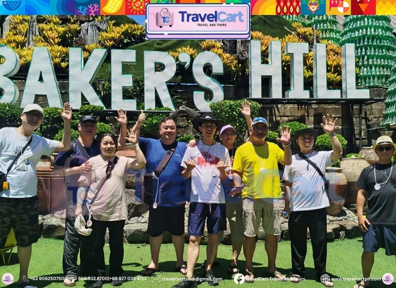 A group of people posing in front of a sign that reads 'BAKER'S HILL' with a TravelCart logo. 4