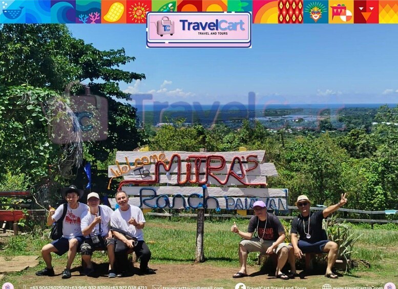 A group of people posing in front of a 'Welcome to Muiras Ranch' sign with a scenic view in the background. 5