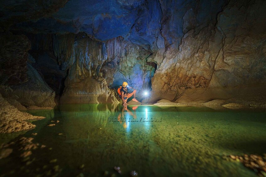 A person exploring a cave with a flashlight. 5