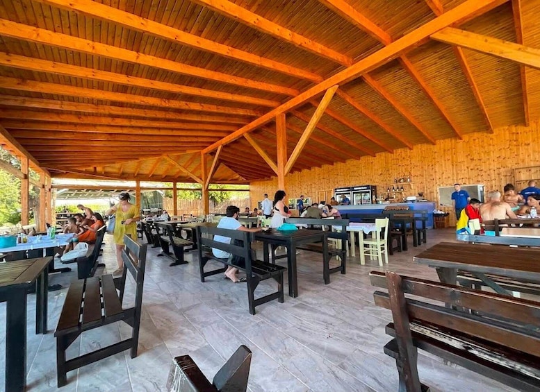 An outdoor wooden pavilion with tables and benches, surrounded by a wooden fence. 4