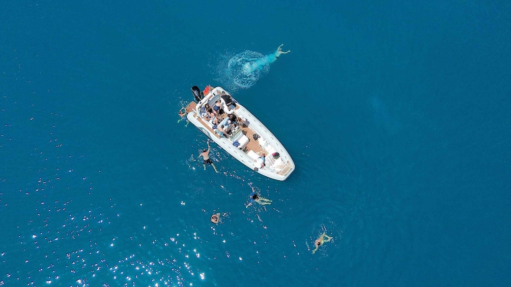 A white boat with people on board, surrounded by water. 1