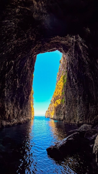 A natural rock formation with a clear blue sky visible through an archway. 5