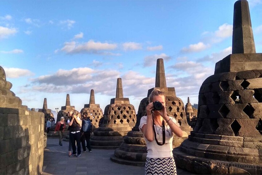 A person taking a photo of stone structures with a camera. 5