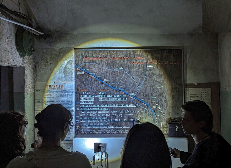 A map with routes and text in a foreign language, displayed in a dimly lit room. 3