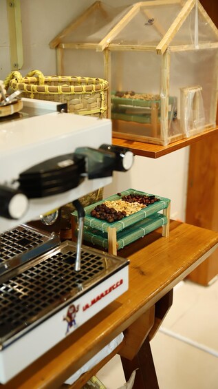 A coffee machine with a basket of coffee beans and a small greenhouse structure. 2