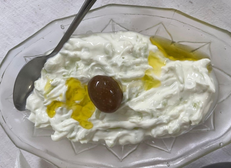 A bowl of yogurt with honey and a raisin. 5