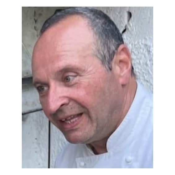 A person wearing a white chef's coat. 1