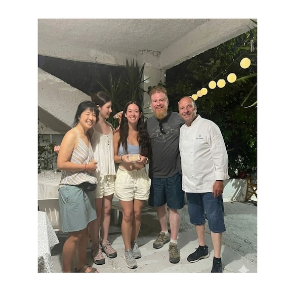 A group of people outdoors under a covered area with string lights. 4