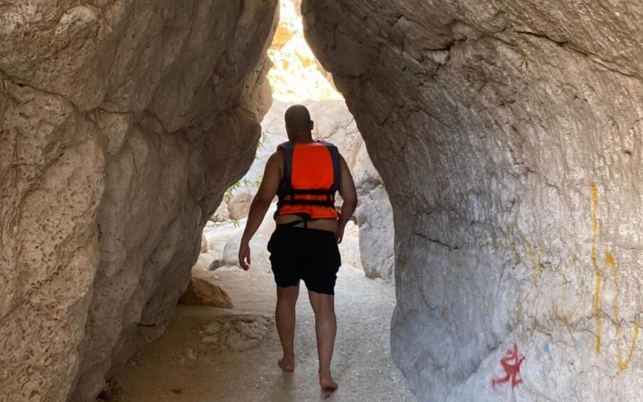 A person walking through a narrow cave passage. 4