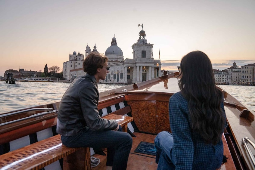 Two people on a boat with a cityscape in the background. 2