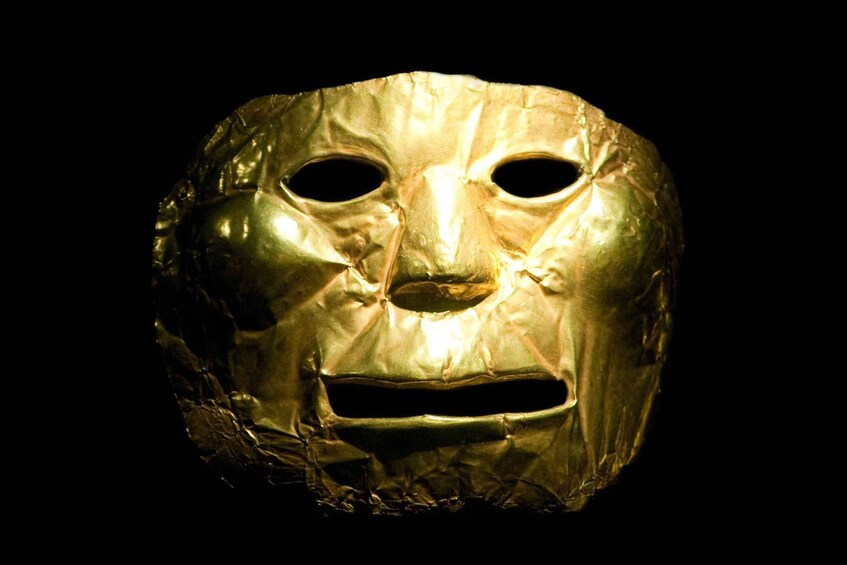 A golden mask with two eye holes and a central mouth hole. 4