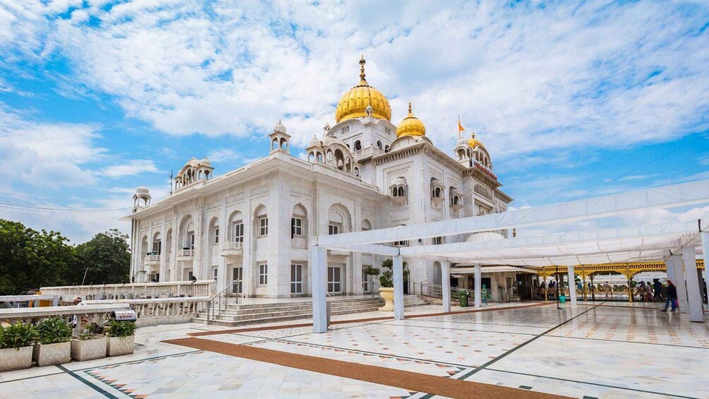 A large white building with golden domes and a covered walkway. 4