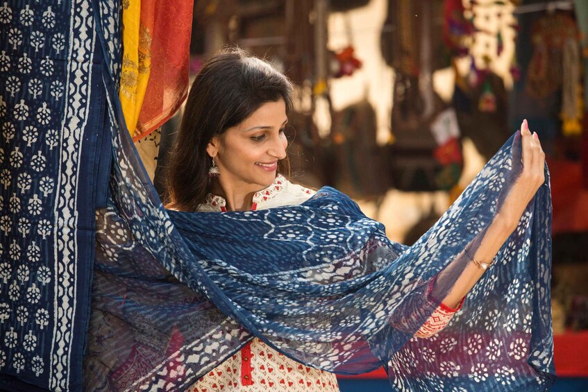 A person holding a blue patterned fabric. 5