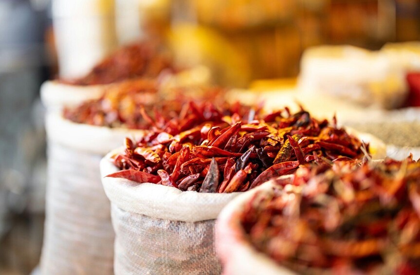 A market stall with bags of dried red chili peppers. 3