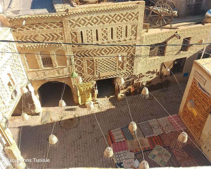 A traditional Tunisian building with intricate brickwork and hanging lanterns. 3