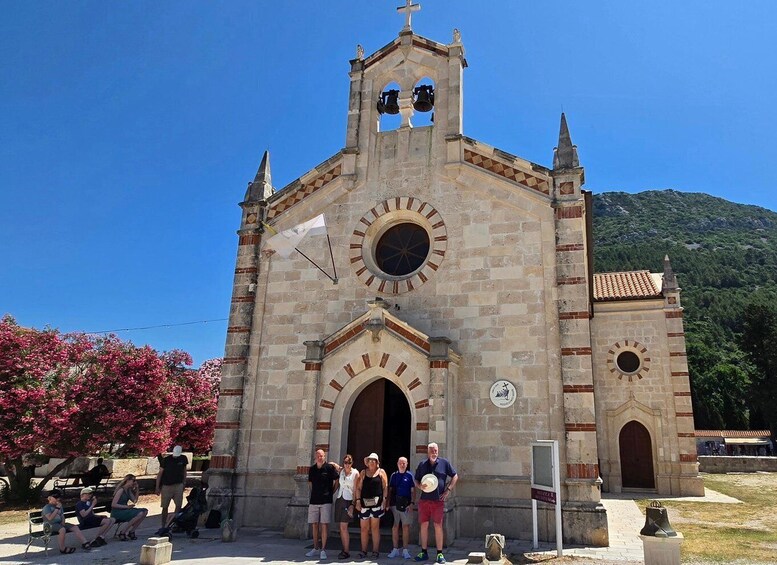 A historic church with a bell tower, a large circular window, and a clock. 1