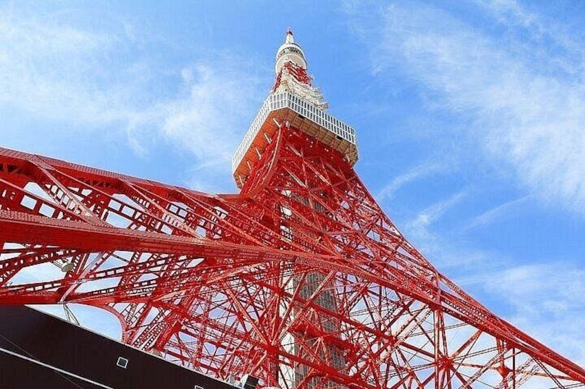 A red Ferris wheel with a white top against a blue sky. 2