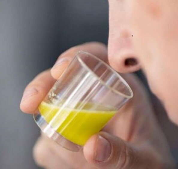 A person holding a glass of orange juice. 1