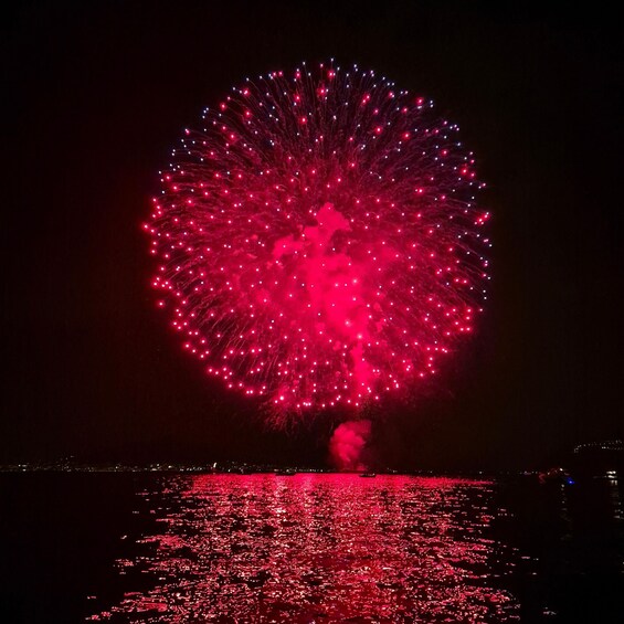 A large firework display over a body of water at night. 5