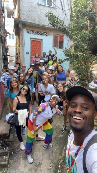 A group of people posing in a narrow alleyway with buildings and greenery in the background. 4