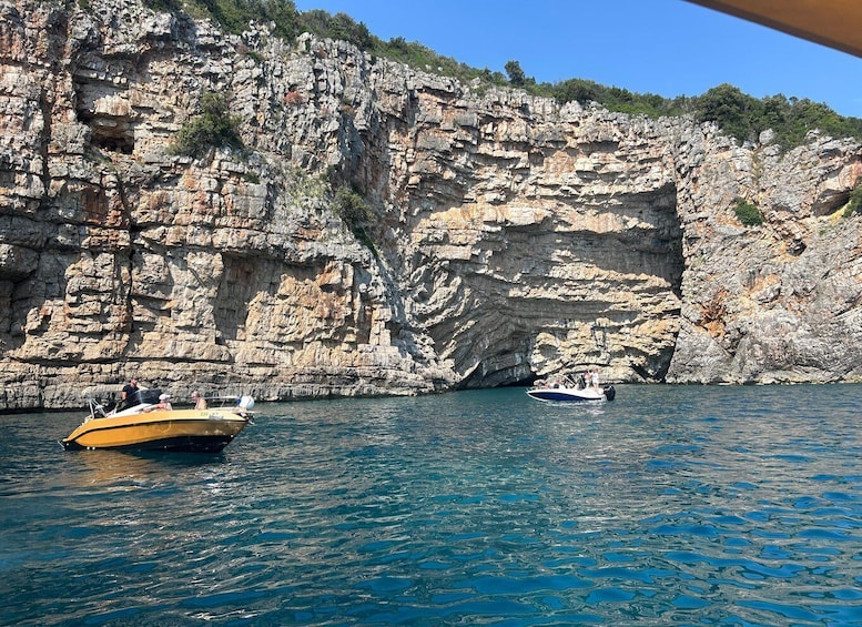 A rocky coastline with boats on the water. 2