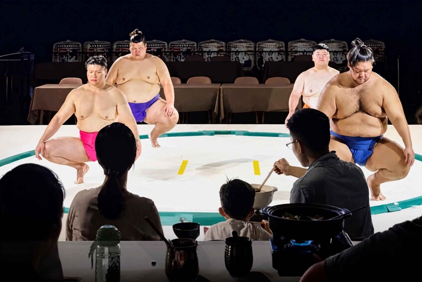 A sumo wrestling match with wrestlers in traditional attire. 1