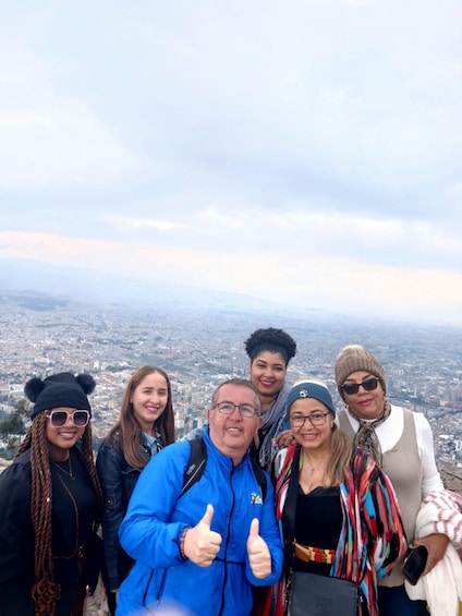 A group of people posing for a photo with a cityscape in the background. 2