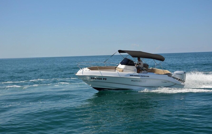 A white motorboat with a canopy, moving on a calm sea. 3
