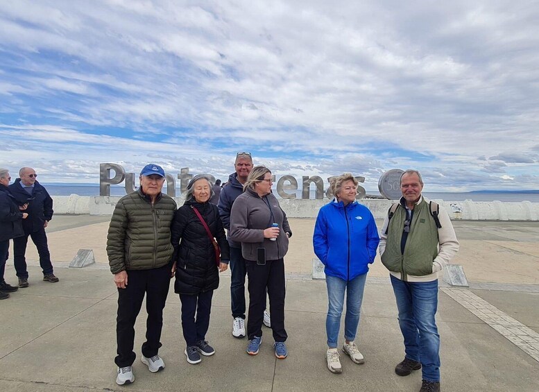 A group of people standing on a concrete platform with a coastal background. 3