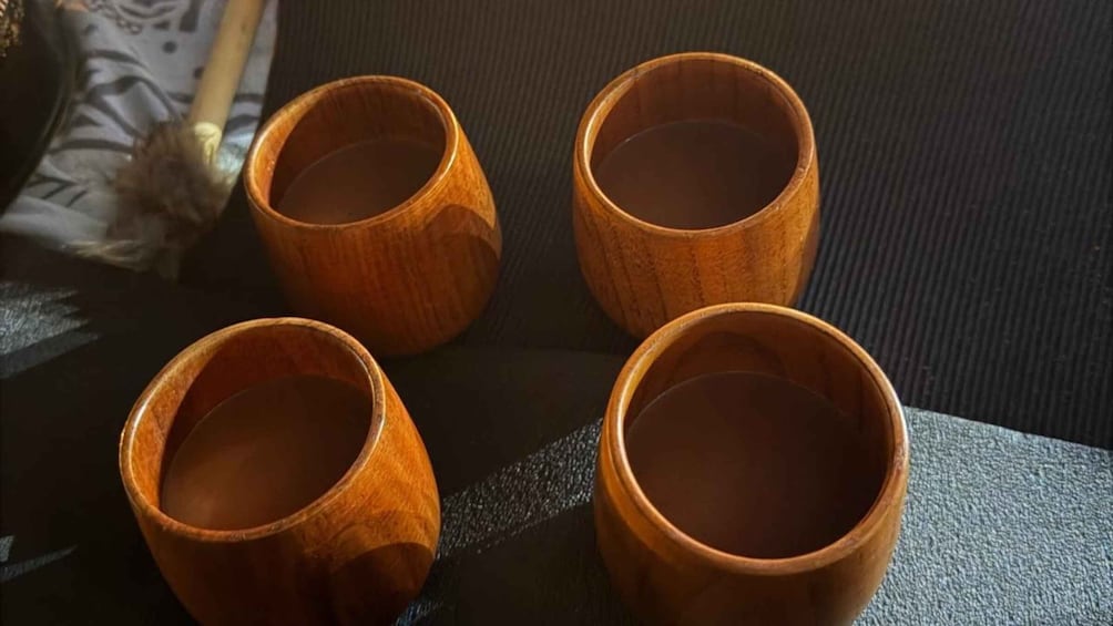 Four wooden cups on a dark surface. 5