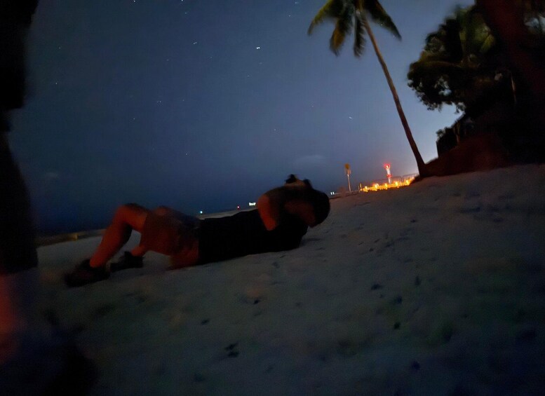 A person lying on the beach at night. 3