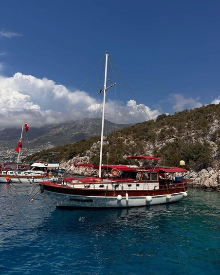 A boat docked at a harbor with a mountainous backdrop. 2