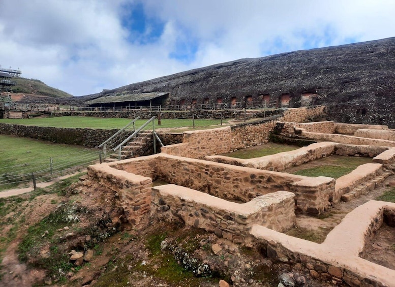 Ancient stone ruins with stepped structures and a stone wall. 3