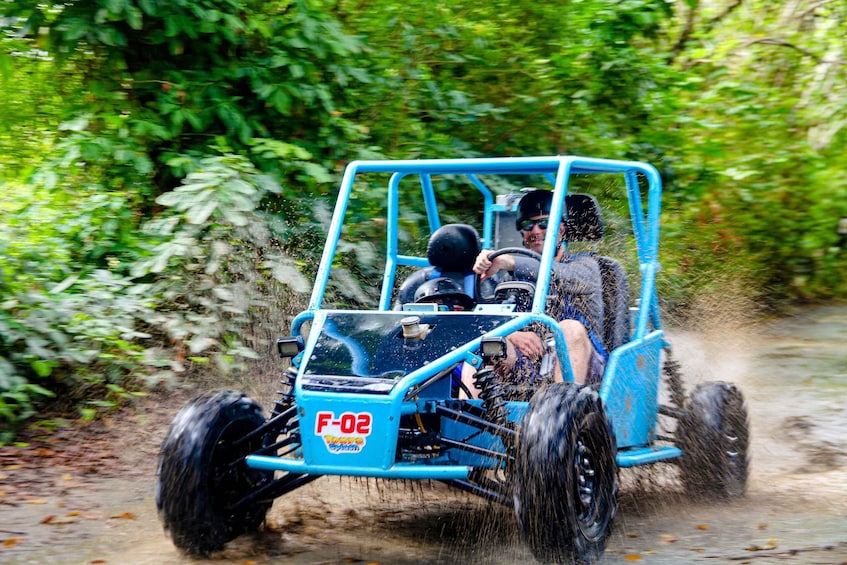 A blue off-road vehicle driving through a forested area. 5