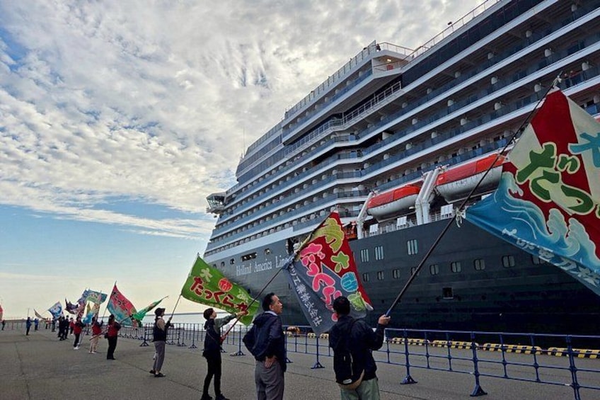 A large cruise ship docked at a port with colorful flags and banners. 3