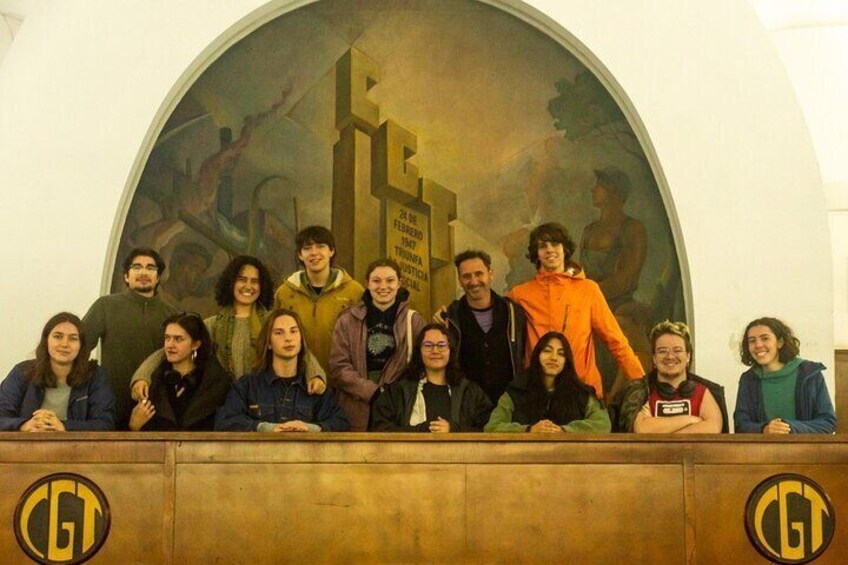 Un grupo de personas posando frente a un gran mural con un reloj y un letrero que dice "24 de Febrero 2017". 4