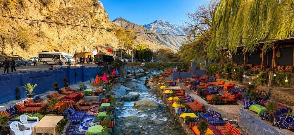 A river with colorful seating areas and a mountainous backdrop. 1
