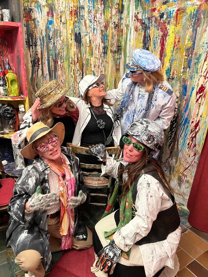 A group of people in a room with a colorful, abstract wall painting. 2