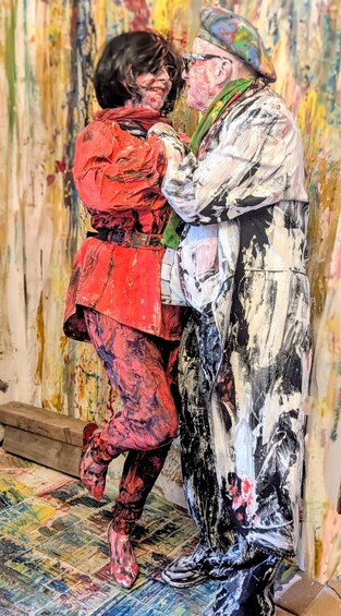 A painting of two people embracing, one in red and the other in white and black, with a textured background. 4