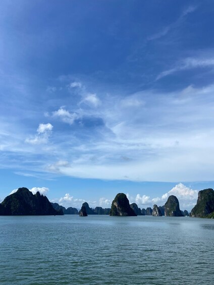 A calm sea with several large limestone islands. 1