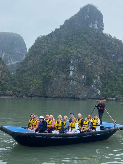 A group of people in a boat on a river, wearing life jackets, with a guide leading them. 3