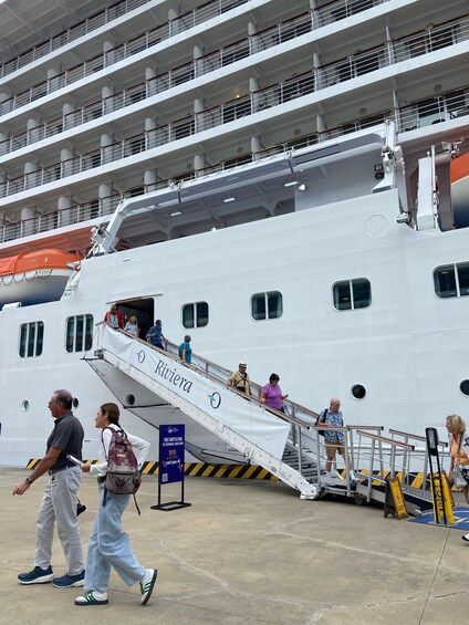 A large cruise ship with people boarding via a staircase. 2