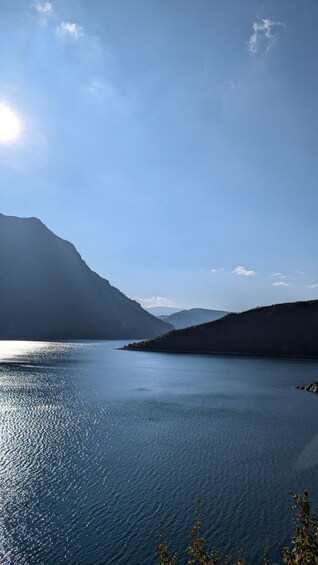 A calm lake with mountains in the background and a clear sky. 3