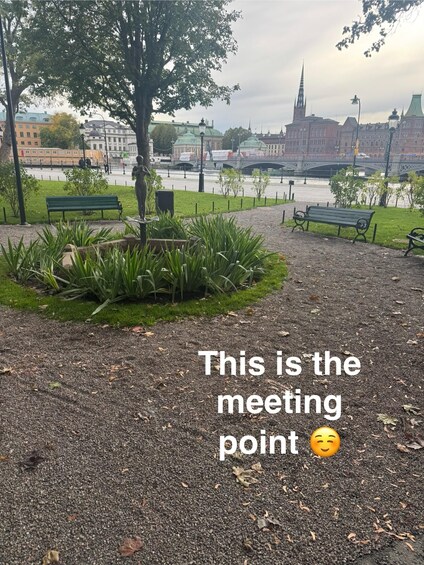 A park with benches, a statue, and a river in the background. 5