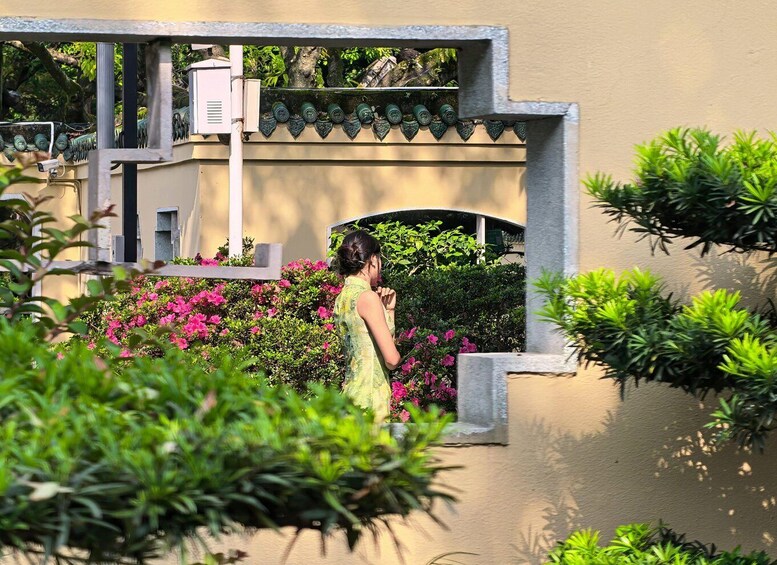 A person in a garden with pink flowers and green foliage. 3