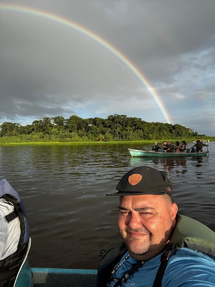 A man in a boat with a rainbow in the background. 1