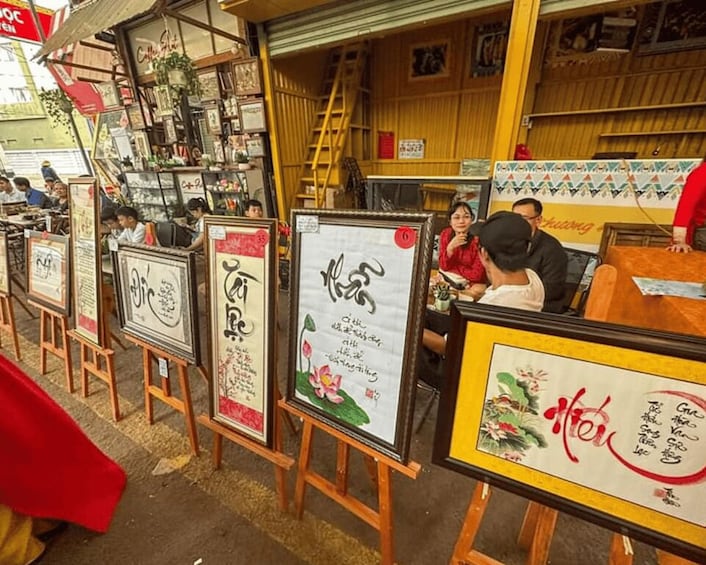 A street market with framed signs and a ladder in the background. 2