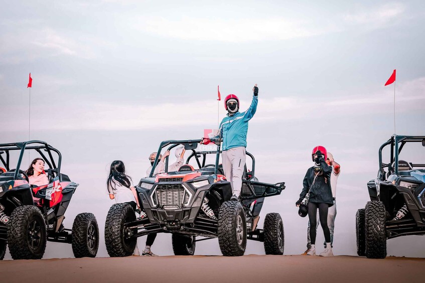 Four off-road vehicles parked on a flat surface with a cloudy sky in the background. 2